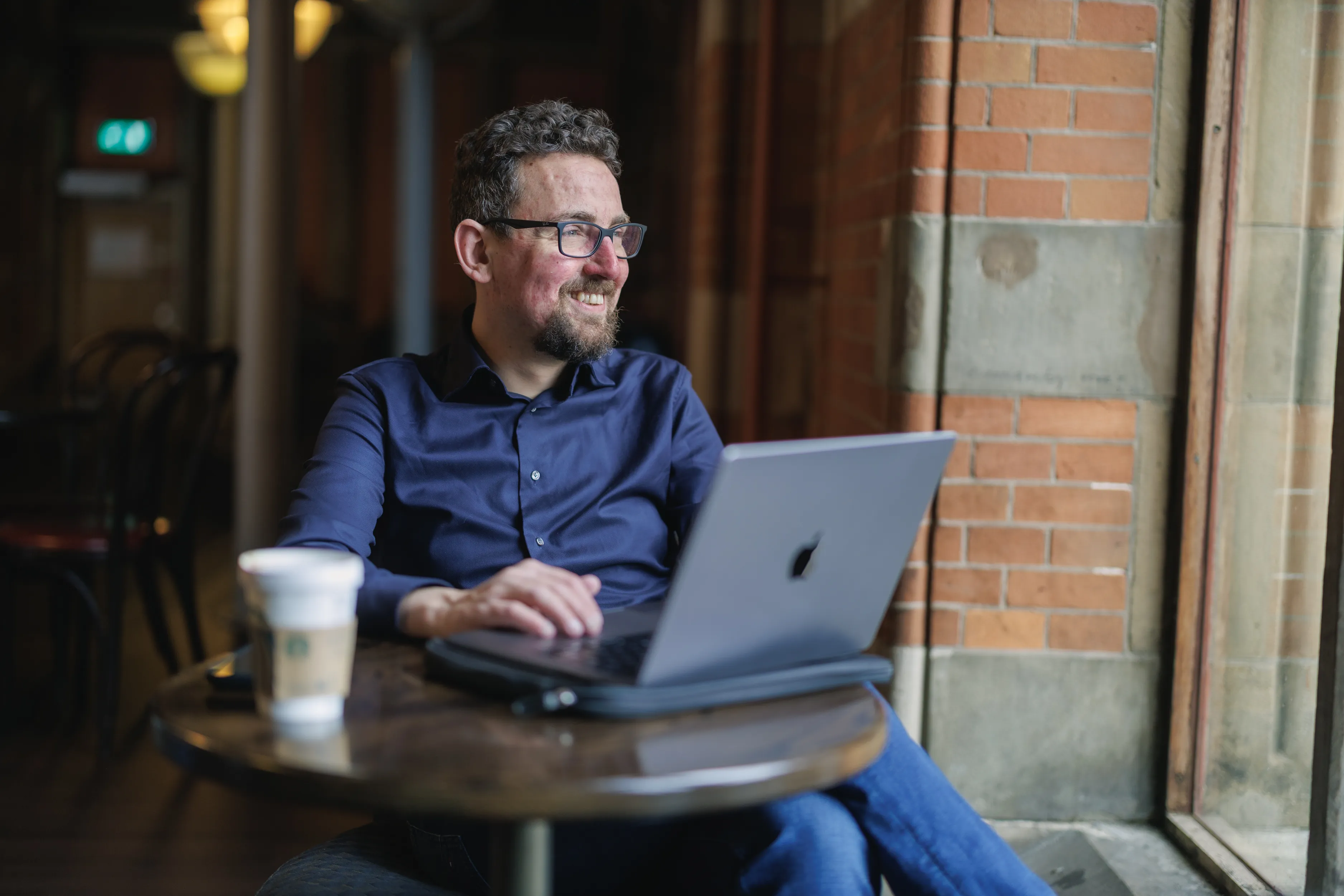 René Goedhart werkt aan lesmateriaal in een café
