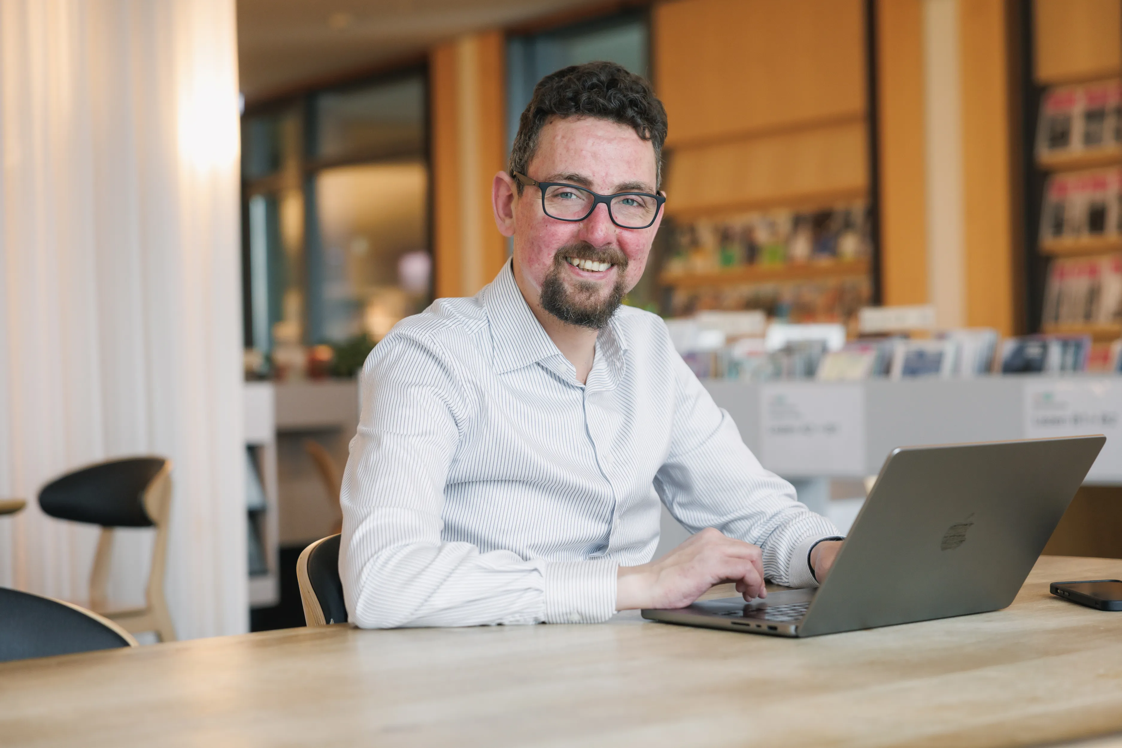 René Goedhart werkt aan zijn laptop, glimlachend
